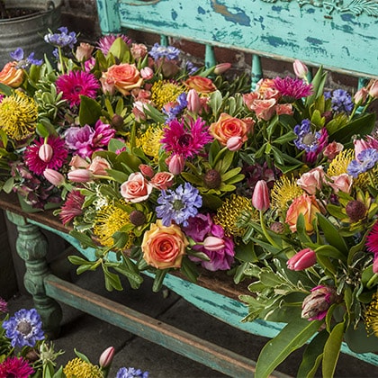 A collection of colorful centerpieces on our blue bench , ready for the party.