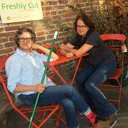 Two tired florists relax after a busy day at the flower shop.